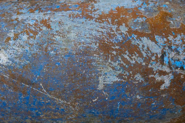 Blue painted concrete wall with mold and cracks