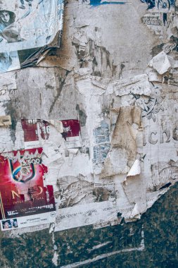 Eski beton duvardaki yırtık ve eski kağıt reklamları