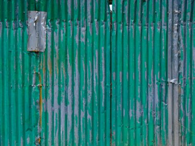 Aqua painted dented aluminum folding doors background texture