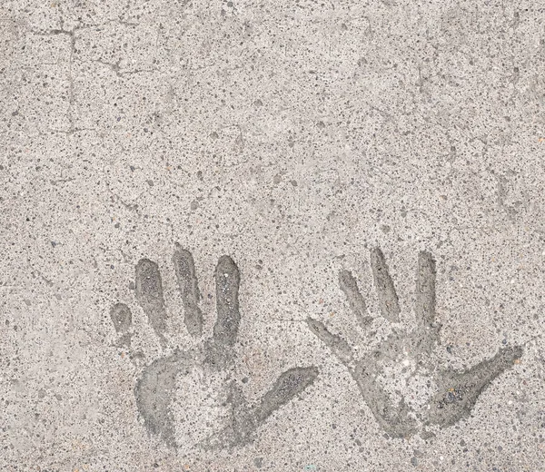Two hand prints in white concrete pavement background and wallpaper texture. Copy space.