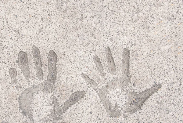 Two hand prints in white concrete pavement background and wallpaper texture. Copy space