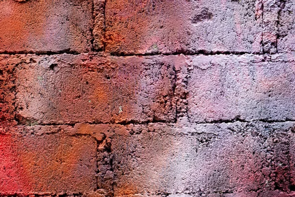 Old red brick wall with white spray paint. Grunge background and wallpaper texture.
