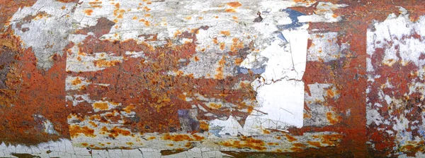 Corroded metal with white paint chipping and rust all over. Background and wallpaper texture