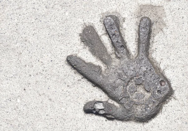 Single wet hand print relief in concrete pavement in Bali, Indonesia. Copy space