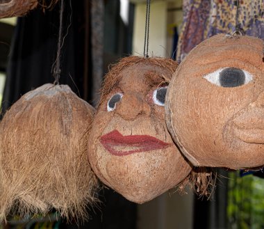 Endonezya, Bali 'deki ağaç dalından sarkan oyulmuş ve boyanmış yüzlü üç hindistan cevizi kabuğu.