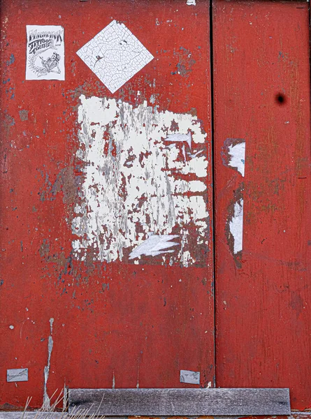 Weathered Red Painted Wood Door White Paper Residue Advertisements — Stock Photo, Image