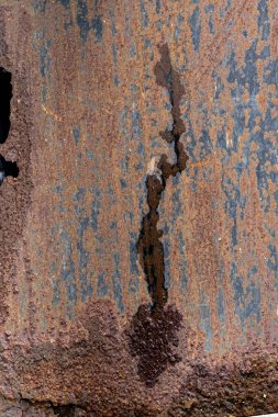 Ortadan aşağı büyük dikey ayrışma ile paslanmış metal levha.