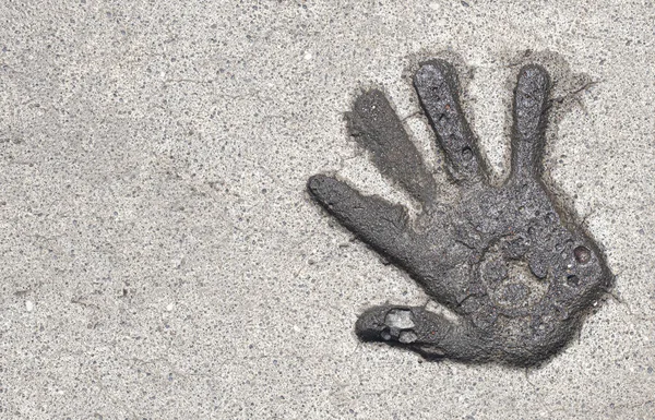 Wet hand print on concrete stone pavement in Bali