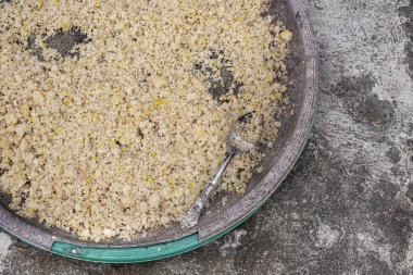 Bali 'de pirinç ve gümüş kaşıkla beton kaldırımda duran kirli seramik tabağın yakın görüntüsü