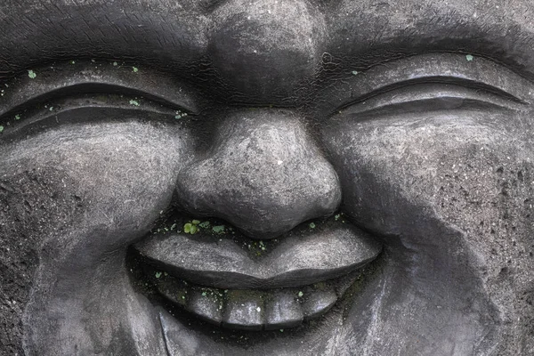 目を閉じて笑みを浮かべて灰色の具体的な仏像の顔を閉じて — ストック写真