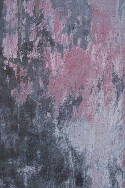 Gri ve gül renginde, siyah lekeli beton duvar.