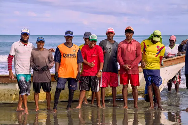 Cartagena, Bolivar Kolombiya - 1 Şubat 2024: Kartagena 'lı balıkçılar kıyıdaki balıkçı teknelerinin yanında denize bakan kameraya gülümsüyorlar