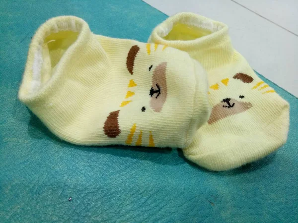 Foto Von Niedlichen Babysocken Gelb Und Einem Meerschweinchengesicht — Stockfoto