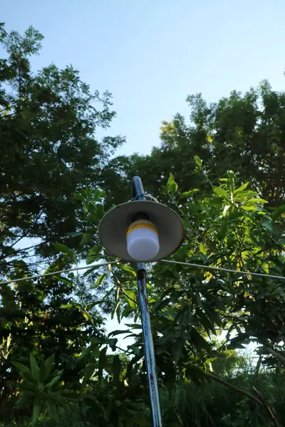 Üzerinde yuvarlak şemsiye olan beyaz bir sokak lambası fotoğrafı.