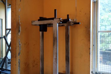 Yıpranmış bir jimnastik salonu, sarı bir duvarın önünde..