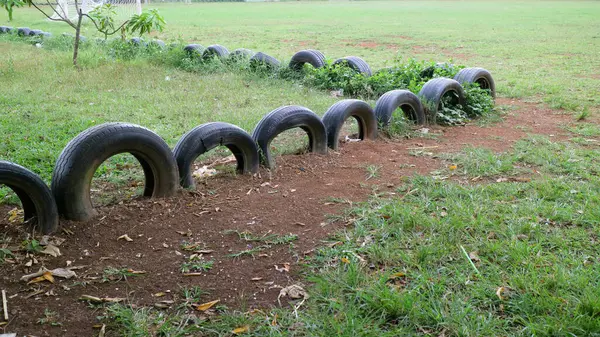 Gömülü lastiklerin yarısı çimenli bir arazide sınır oluşturuyor..