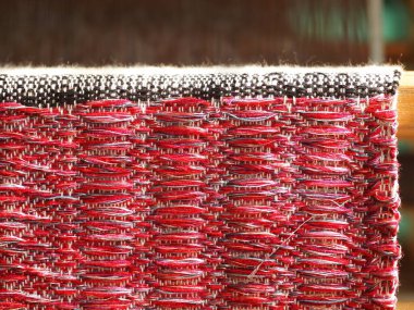 Üniversite moda ve tekstil atölyesinde geleneksel malzemeler ve ipliklerle eğitim sanatı ve el işi yapmak için kullanılan küçük bir el yapımı dokuma makinesinin parçaları..