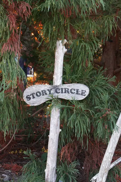 Wooden post sign for story time or story circle located outside in nature