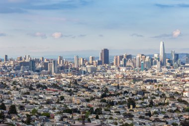 Güneşli, mavi bir günde, önünde evler ve binalar olan San Francisco Skyline.