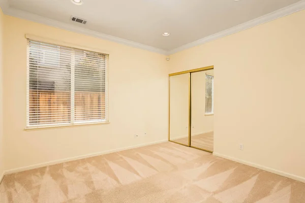 A vacant room with cream walls and beige carpet. Great for virtual staging