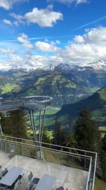 İsviçre Alpleri, Titlis Dağı 'nın karla kaplı zirvelerini Stanserhorn gözlem güvertesinden gösteriyor. 1 Ekim 2024, Stans, İsviçre. Bu video İsviçre 'nin büyüleyici bir perspektifini sunar