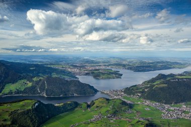 A breathtaking panoramic view from the summit of Stanserhorn, capturing Lake Lucerne and the surrounding alpine landscape. Snow-capped peaks, lush valleys, and the iconic Swiss scenery create a clipart