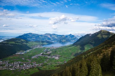 Stanserhorn 'un tepesinden nefes kesen manzarayı yakalayarak, bu görüntü aşağıdaki yemyeşil vadiyi, Lucerne Gölü' nü ve Rigi Dağı 'nın yükselişini gözler önüne seriyor.