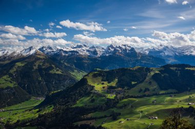 Stunning panorama from the summit of Stanserhorn, showcasing snow-dusted Alpine peaks and lush green valleys below. The clear skies and crisp mountain air add to the breathtaking beauty of this Swiss clipart