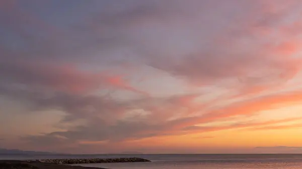 Marina di Ce 'nin önündeki Akdeniz' in üzerinde kızıl bir günbatımı