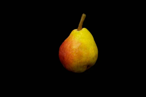 on a black background a red yellow pear