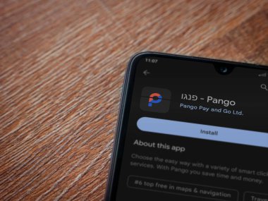 Lod, Israel - July 16,2023: Pango app play store page on smartphone on wooden background. Top view flat lay with copy space.