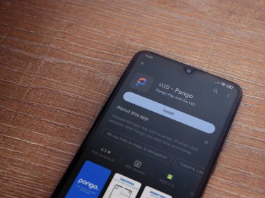 Lod, Israel - July 16,2023: Pango app play store page on smartphone on wooden background. Top view flat lay with copy space.