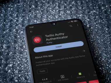 Lod, Israel - July 16,2023: Twilio Authy Authenticator app play store page on smartphone on a metallic background. Close up top view flat lay.