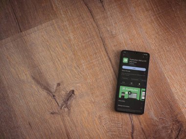 Lod, Israel - July 16,2023: Pushbullet app play store page on smartphone on wooden background. Top view flat lay with copy space.