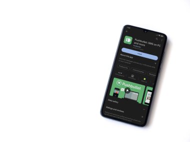 Lod, Israel - July 16,2023: Pushbullet app play store page on smartphone on white background. Top view flat lay with copy space.