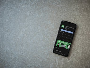 Lod, Israel - July 16,2023: Pushbullet app play store page on smartphone on ceramic stone background. Top view flat lay with copy space.