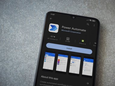 Lod, Israel - July 16,2023: Power Automate app play store page on smartphone on ceramic stone background. Top view flat lay with copy space.