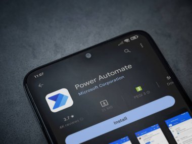 Lod, Israel - July 16,2023: Power Automate app play store page on smartphone on a dark marble stone background. Top view flat lay with copy space.