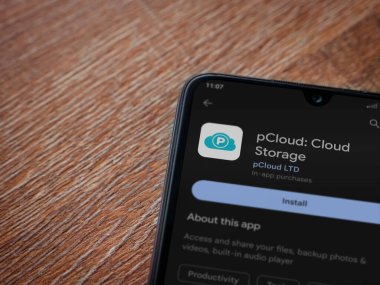 Lod, Israel - July 16,2023: pCloud app play store page on smartphone on wooden background. Top view flat lay with copy space.