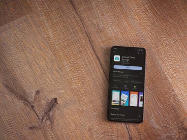 Lod, Israel - July 16,2023: pCloud app play store page on smartphone on wooden background. Top view flat lay with copy space.