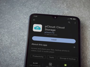 Lod, Israel - July 16,2023: pCloud app play store page on smartphone on ceramic stone background. Top view flat lay with copy space.
