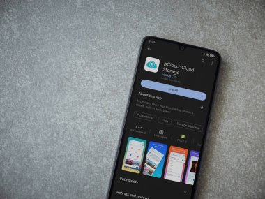 Lod, Israel - July 16,2023: pCloud app play store page on smartphone on ceramic stone background. Top view flat lay with copy space.
