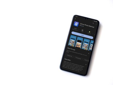 Lod, Israel - July 16,2023: IDrive Photo Backup app play store page on smartphone on white background. Top view flat lay with copy space.