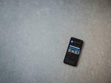 Lod, Israel - July 16,2023: IDrive Photo Backup app play store page on smartphone on ceramic stone background. Top view flat lay with copy space.