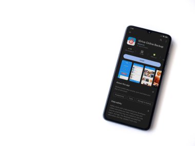 Lod, Israel - July 16,2023: IDrive Online Backup app play store page on smartphone on white background. Top view flat lay with copy space.
