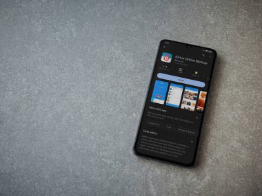 Lod, Israel - July 16,2023: IDrive Online Backup app play store page on smartphone on ceramic stone background. Top view flat lay with copy space.