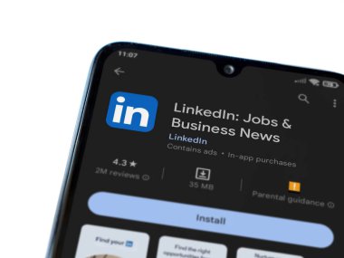 Lod, Israel - July 16,2023: LinkedIn app play store page on smartphone on white background. Top view flat lay with copy space.