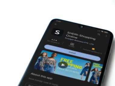 Lod, Israel - July 16,2023: Shein app play store page on smartphone on white background. Top view flat lay with copy space.