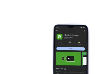 Lod, Israel - July 16,2023: Unified Remote app play store page on smartphone on white background. Top view flat lay with copy space.