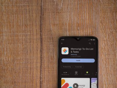 Lod, Israel - July 16,2023: Memorigi app play store page on smartphone on wooden background. Top view flat lay with copy space.